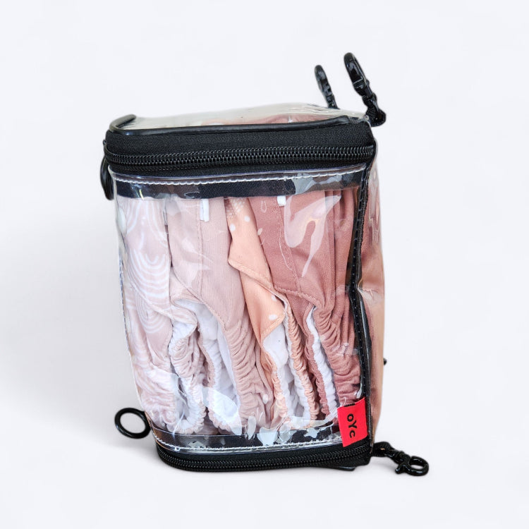 OUT YNDR CLUB wet clothes pod with zipper top and bottom, side view packed with four modern cloth nappies