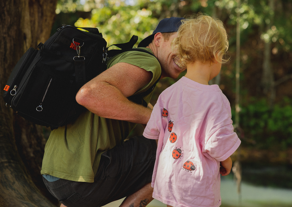 Parent juggling a cluttered nappy bag
