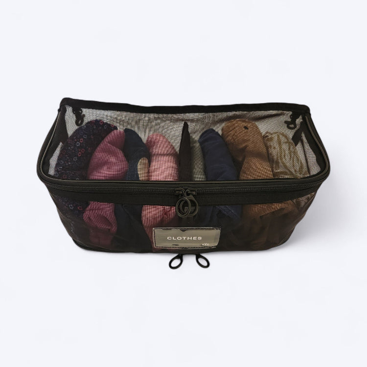 OUT YNDR CLUB Medley baby bag, black mesh pod, top angled view filled with children's clothes
